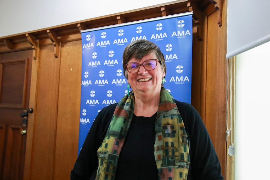 A woman smiling, looking into the camera.