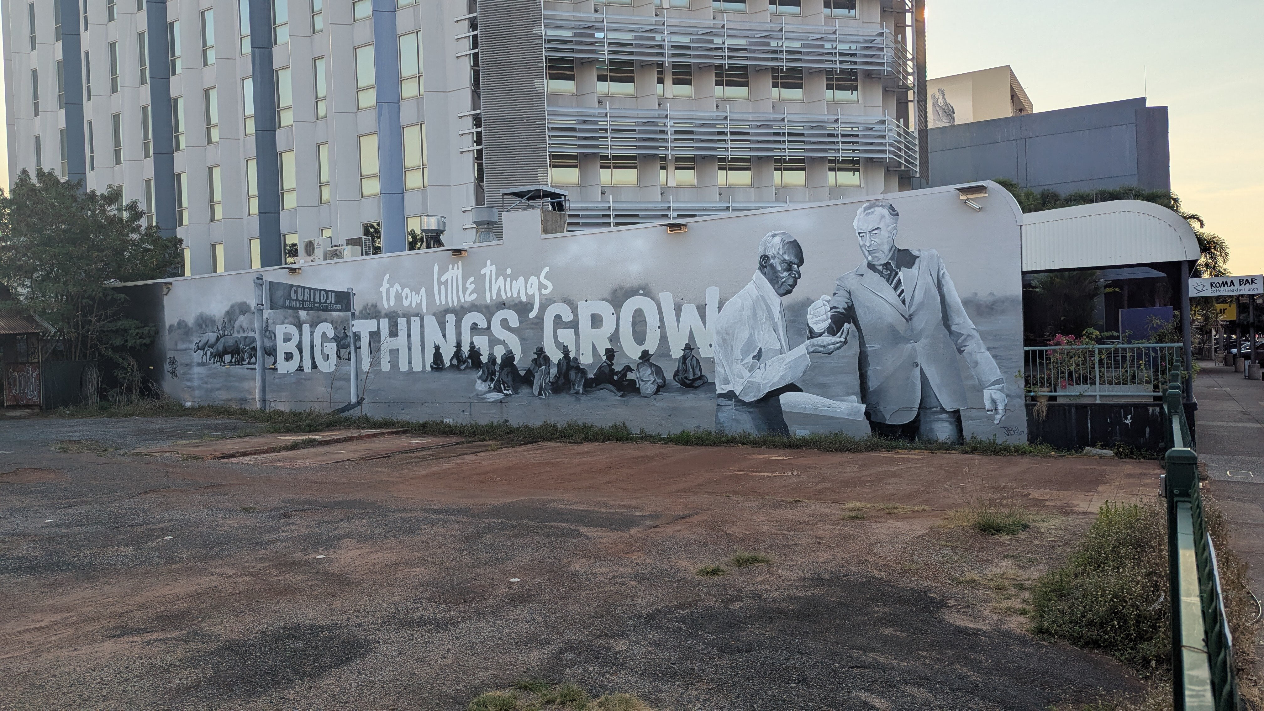 A politician pouring sand into the hand of an Indigenous leader.