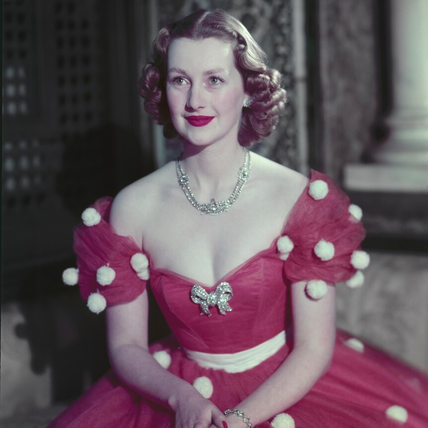 A young woman in a red evening gown and diamond necklace