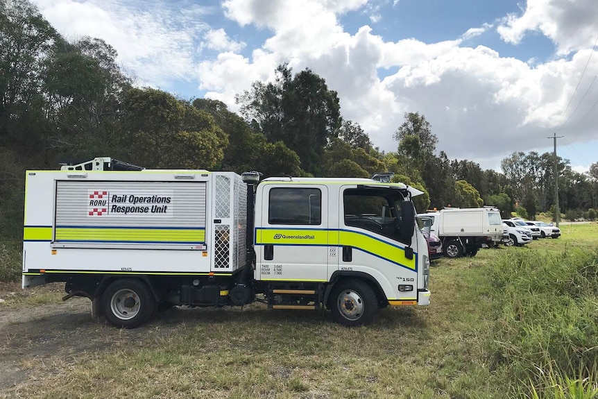 Investigators and vehicles parked on grass at scene where three 17-year-old boys suffered serious burns.