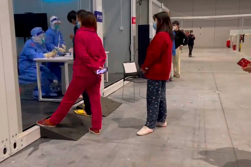 People in quarantine queue for medical help.