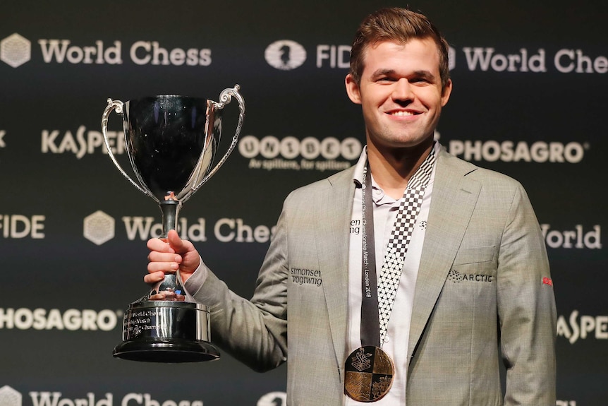 Magnus Carlsen lifts trophy after winning world chess championship