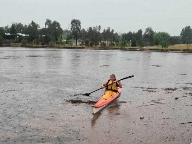 A woman in a kayak in the rain.