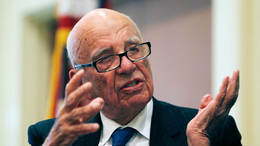 Rupert Murdoch gestures with both hands while speaking.