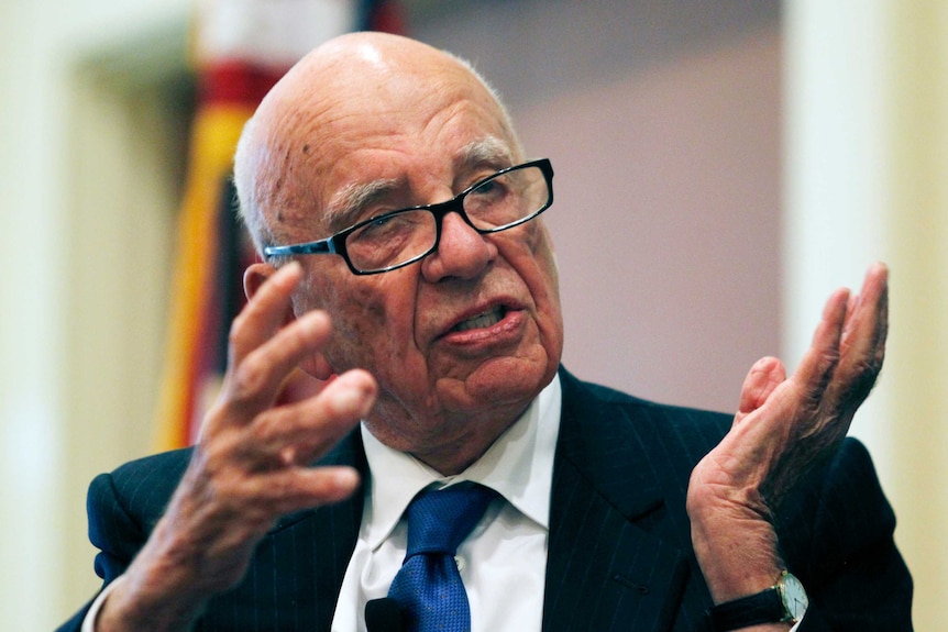 Rupert Murdoch gestures with both hands while speaking.