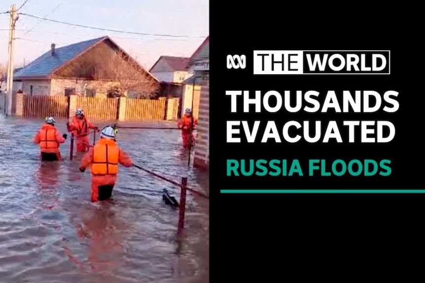Thousands Evacuated, Russia Floods: Emergency workers in fluoro orange wade through floodwaters in a village.