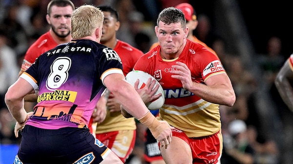 A man runs the ball during a rugby league match