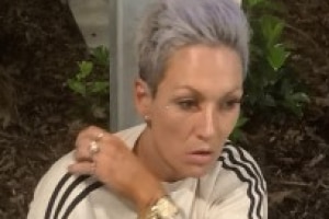 Photo of woman with light purple short hair and rings on fingers.