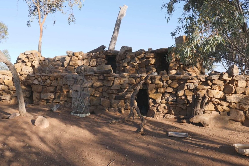 A large structure made of brown rocks with randomly placed openings for bettongs to hide in.