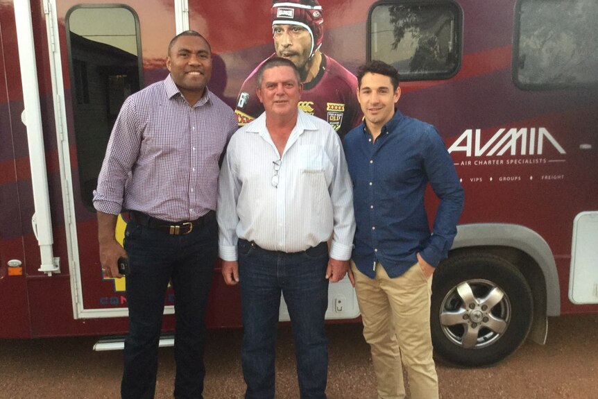 Three men standing in front of the maroon van