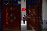 A Uyghur child plays alone in the courtyard of a home in Xinjiang.