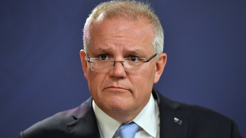 A close up photo of Scott Morrison with a serious expression on his face. He is wearing a suit.