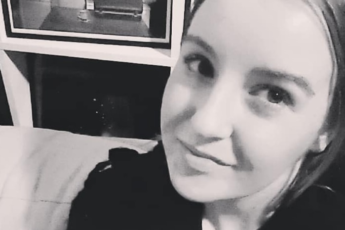 A black and white Facebook photo of Cait O'Brien smiling.