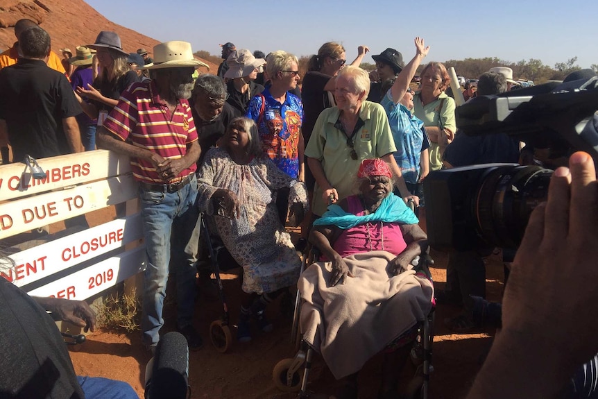 Traditional owners and scores of media workers at the base of Uluru.