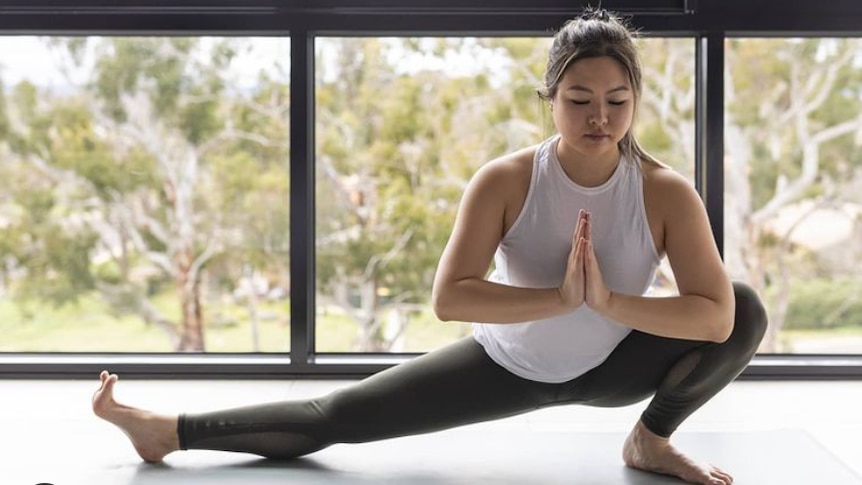 Evie Kuang practising yoga in a story about setting realistic exercise goals that don't focus on weight and size