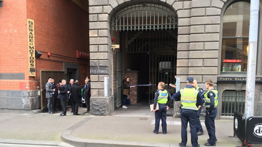 A group of police outside a building in Melbourne's CBD where a woman and child have died