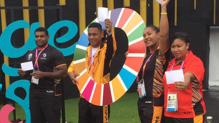 Athletes from the PNG team pose for a photo