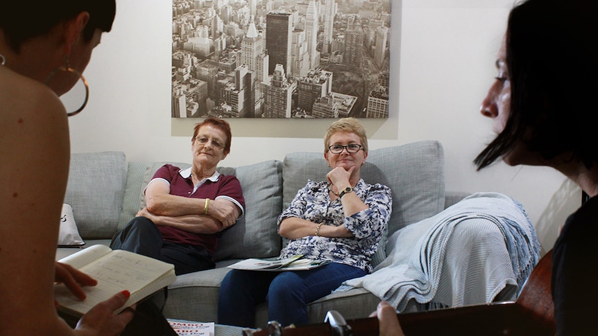 Defence widows Lyn Kerwin and Suzi Vincent sit and listen to The Soldier's Wife sing the music they wrote from their stories.