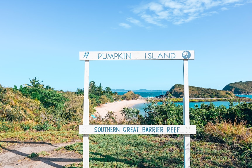 A beach shot of a sign saying pumpkin island