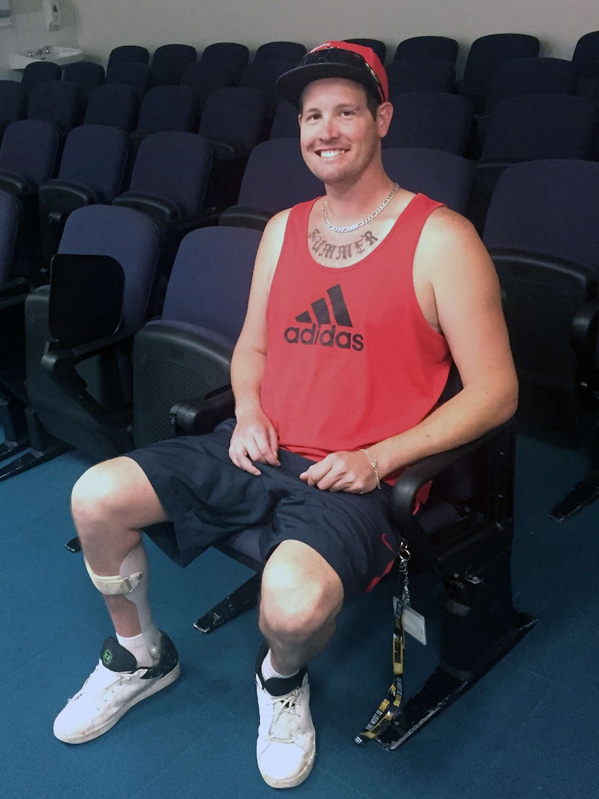 Craig Kellenberg sitting down, wearing a leg brace.