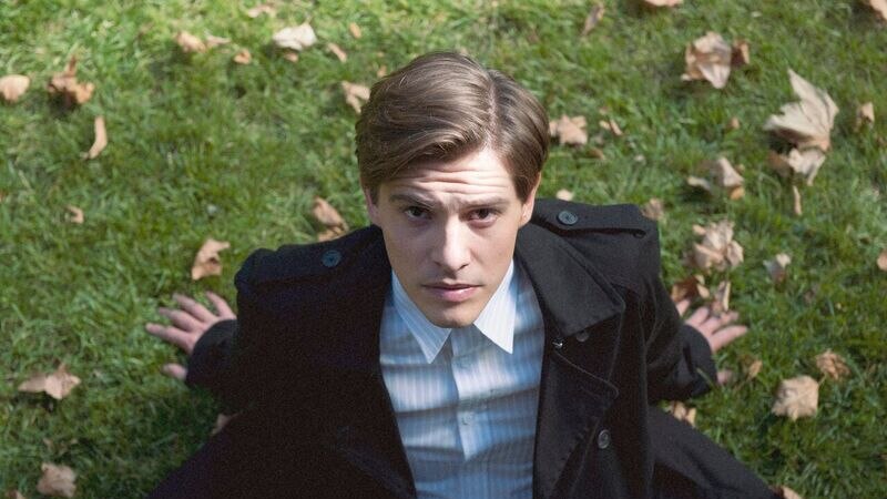 Image of actor Xavier Samuel sitting on grass looking up at the camera from the film The Death and Life of Otto Bloom