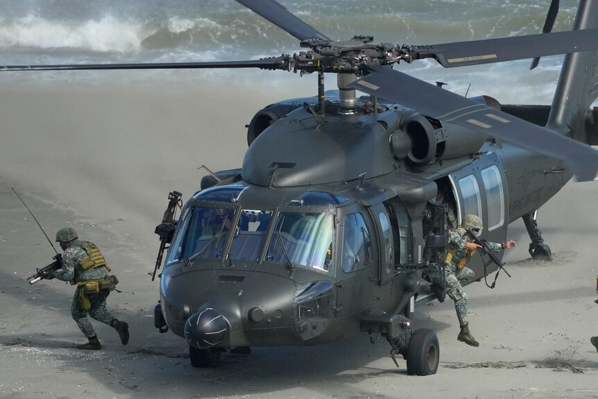 Picture of armed soldiers coming out of a military helicopter