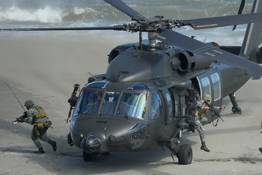 Picture of armed soldiers coming out of a military helicopter