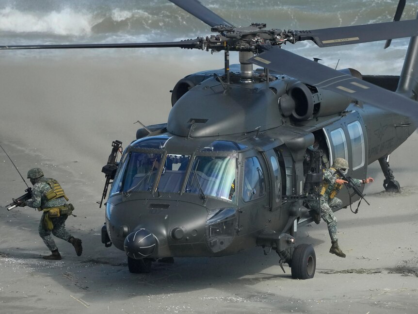 Picture of armed soldiers coming out of a military helicopter