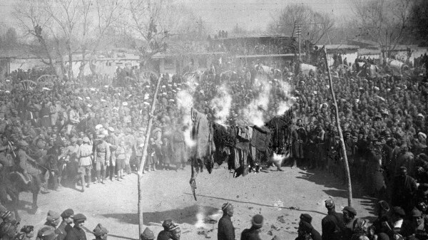 Black and white photograph of a crowd watching women burn their veils on International Women's Day in Uzbekistan in the 1920s