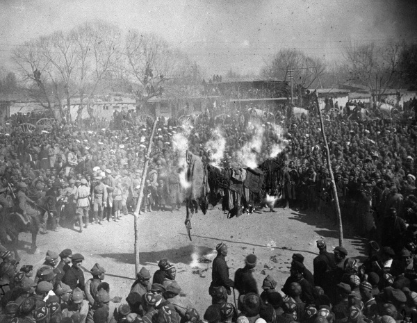 Black and white photograph of a crowd watching women burn their veils on International Women's Day in Uzbekistan in the 1920s