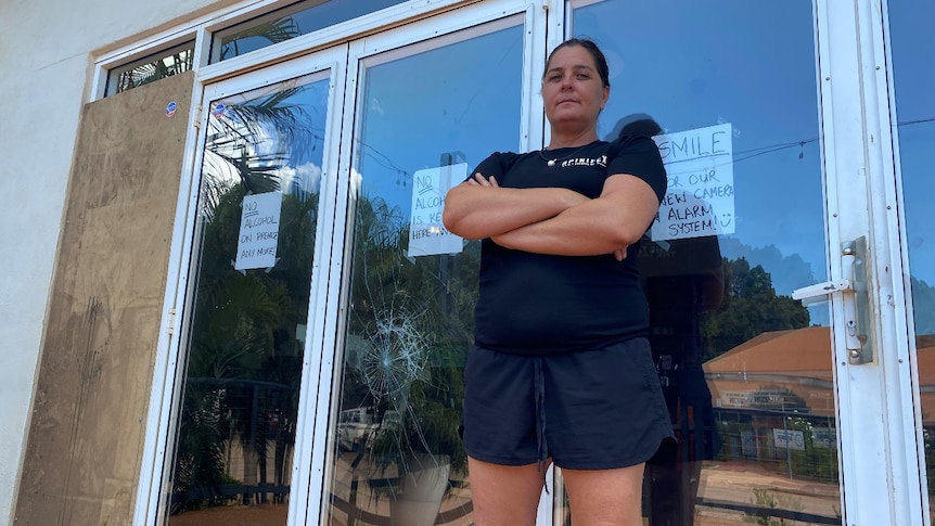 woman in front of smashed glass windows 