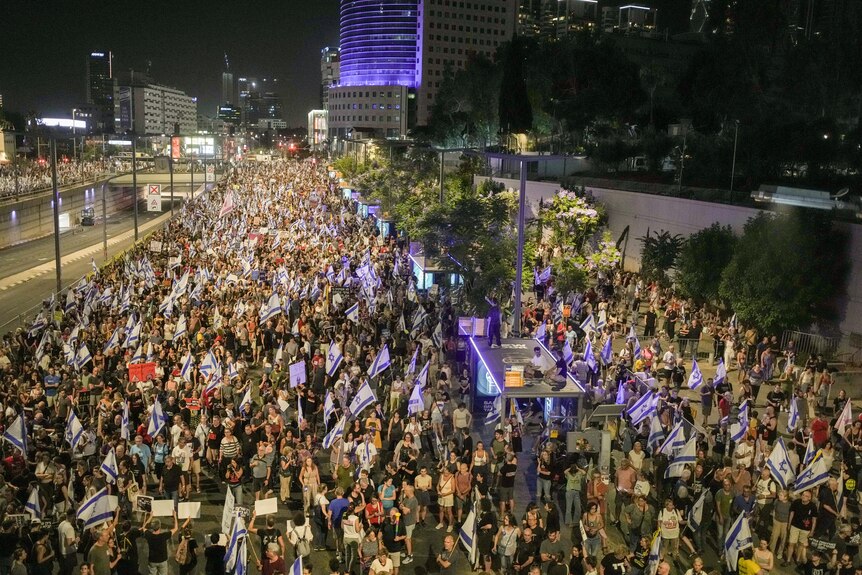 A large crowd of people protest against Israeli Prime Minister Benjamin Netanyahu's government.