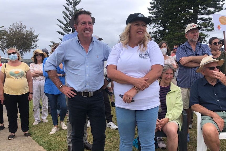Deputy Premier Paul Toole and Nationals candidate for Port Macquarie Peta Pinson stand together with a crowd in the background.