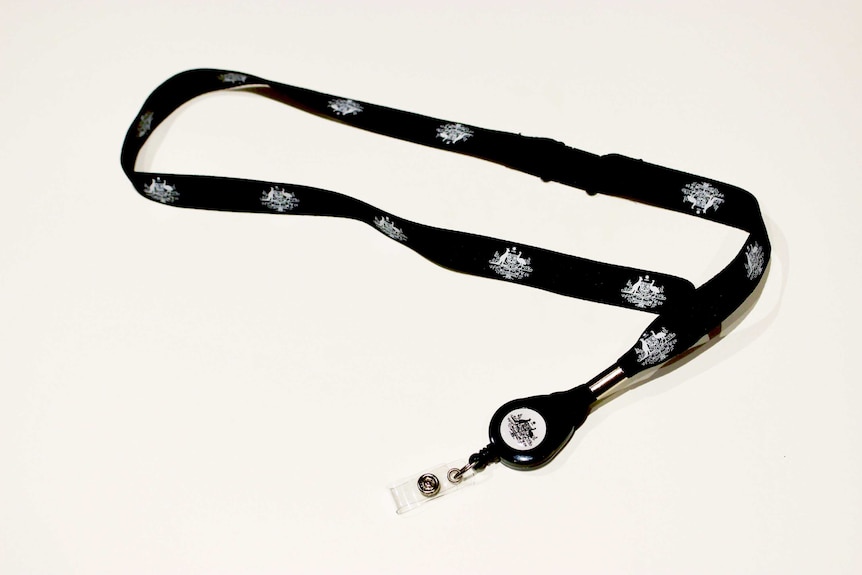 A lanyard with the Australian Government coat of arms on it sits on a white table.