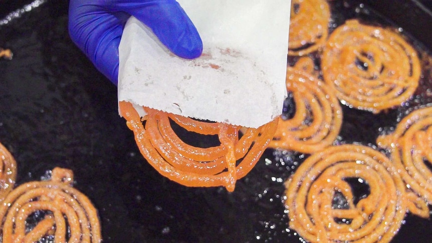 Person holding jalebi, a popular sweet treat in Pakistan, at a Ramadan night market in Lakemba, in Sydney's west.