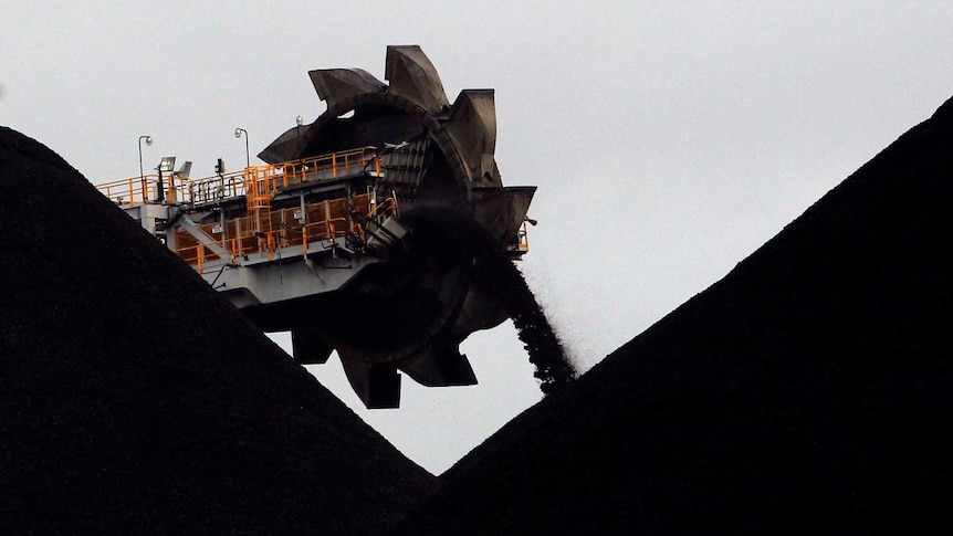 A reclaimer places coal in stockpiles at the coal port in Newcastle, Australia
