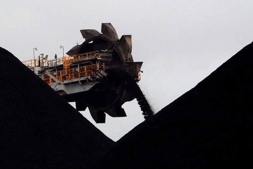 A reclaimer places coal in stockpiles at the coal port in Newcastle, Australia