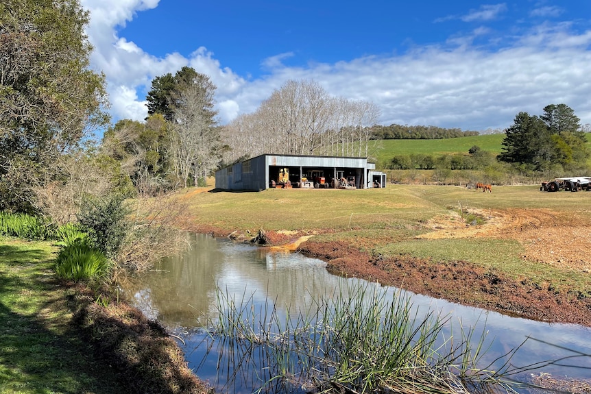 A river running between green hills and farmland.