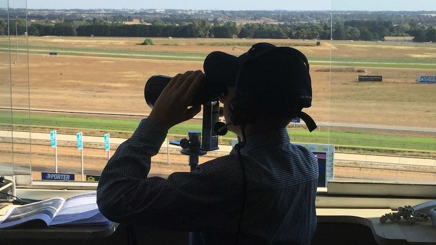 14 year old Isaac Jantzen stands in the racecourse announcer box, looking out over the field