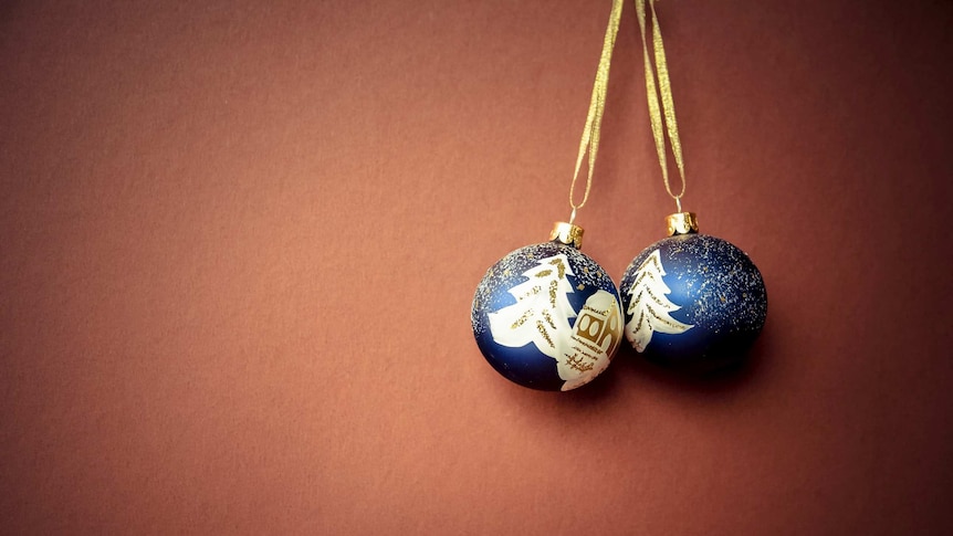 two blue christmas ornaments hanging together