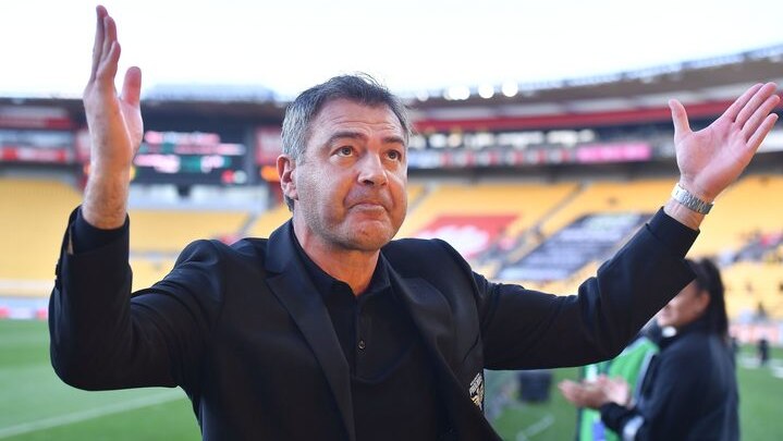 Wellington Phoenix coach Mark Rudan raises his hands to fans of the club at the end of a match