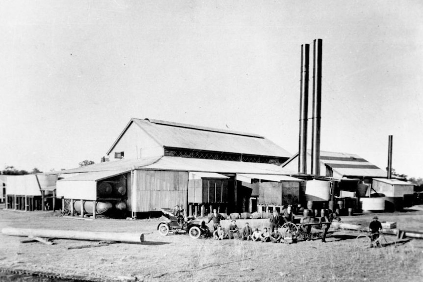 grainy, black and white photo of the Maryborough mill from 1910 with workers and an old timey car