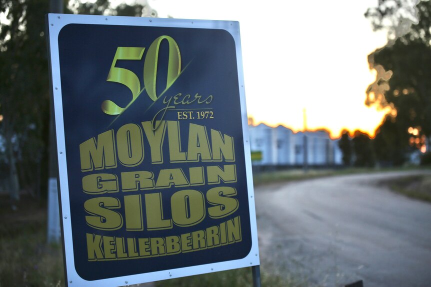 A close-up shot of a sign reading '50 years, est 1972, Moylan Grain Silos Kellerberrin', by the side of a road.
