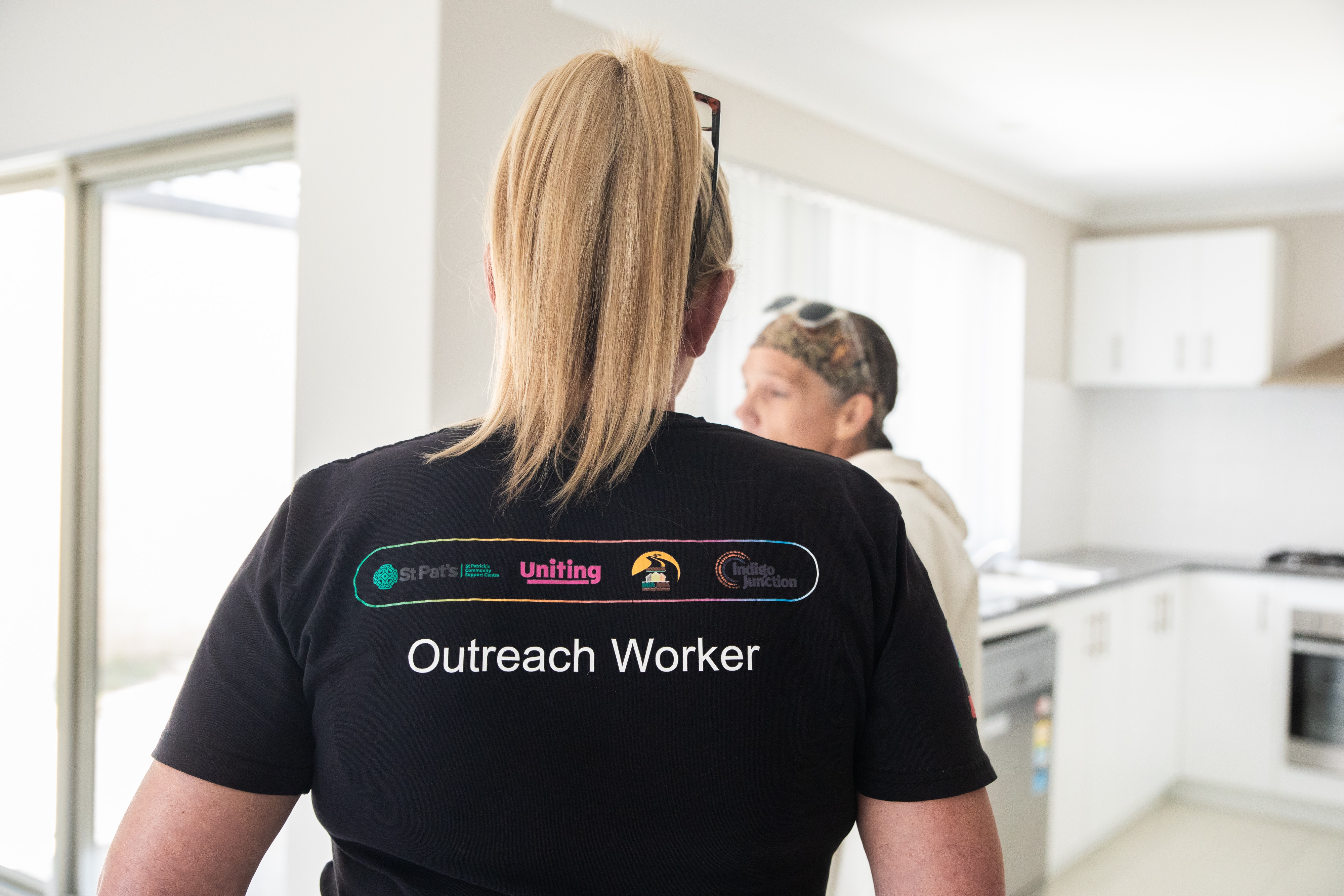 Uma mulher vista por trás vestindo uma camiseta com as palavras 