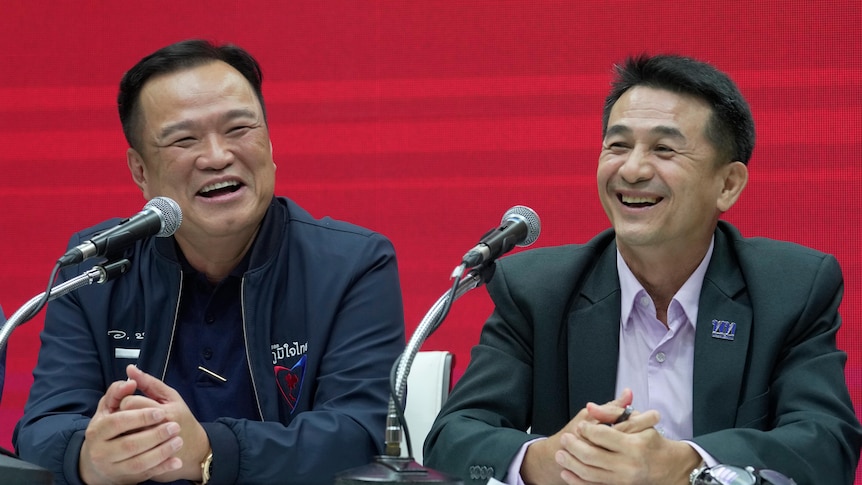 Anutin Charnvirakul and Chonlanan Srikaew smile during a press conference announcing coalition party.