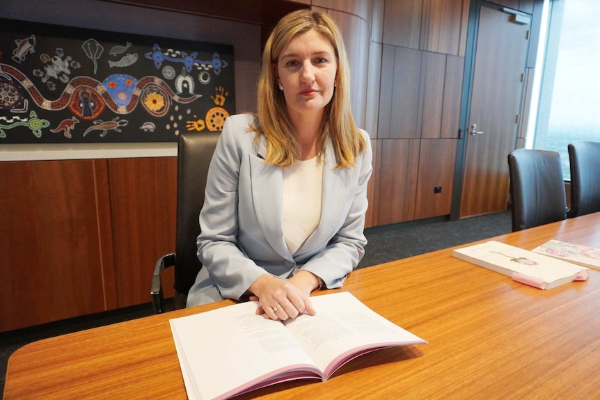 A woman sits in a board room.