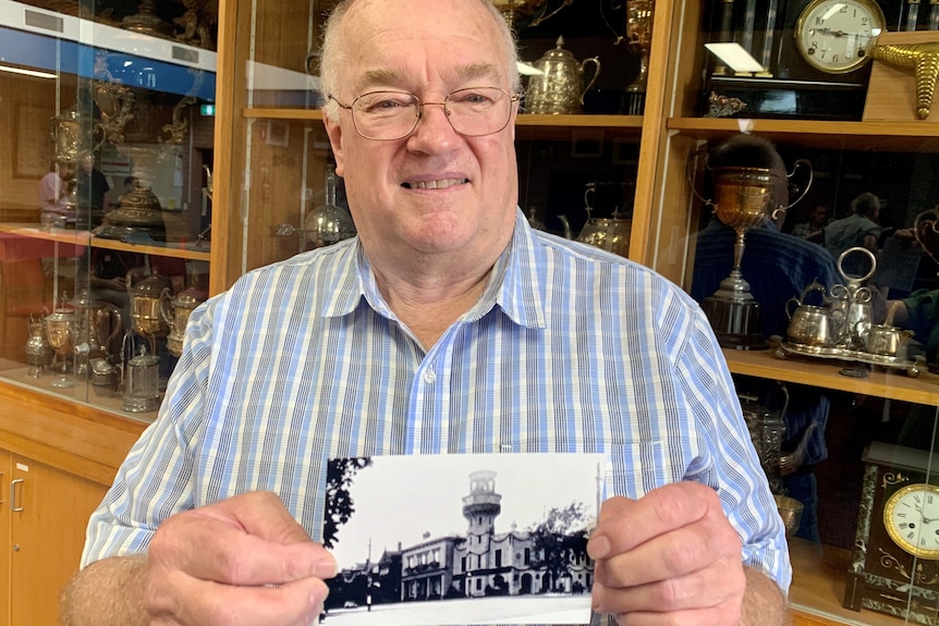 A man in his seventies holds an image of the old ballarat city fire station