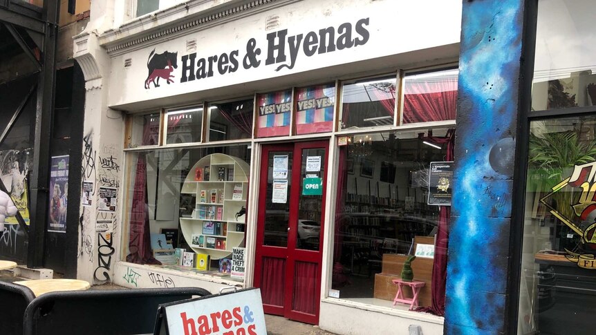 A white shopfront with the words 'Hares & Hyenas' in black text and books in the window.