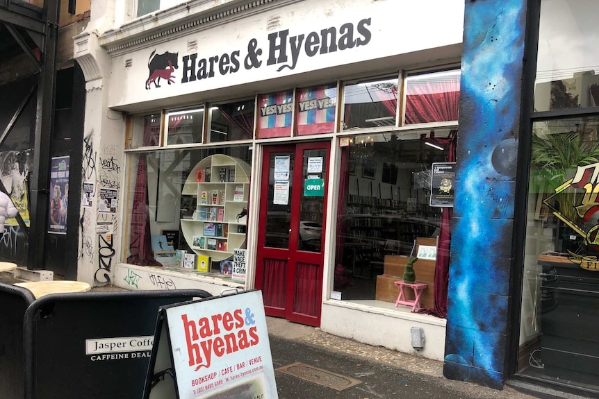 A white shopfront with the words 'Hares & Hyenas' in black text and books in the window.