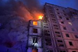 Fire and smoke seen at damaged residential building after Russian missile strike in Uman at night.
